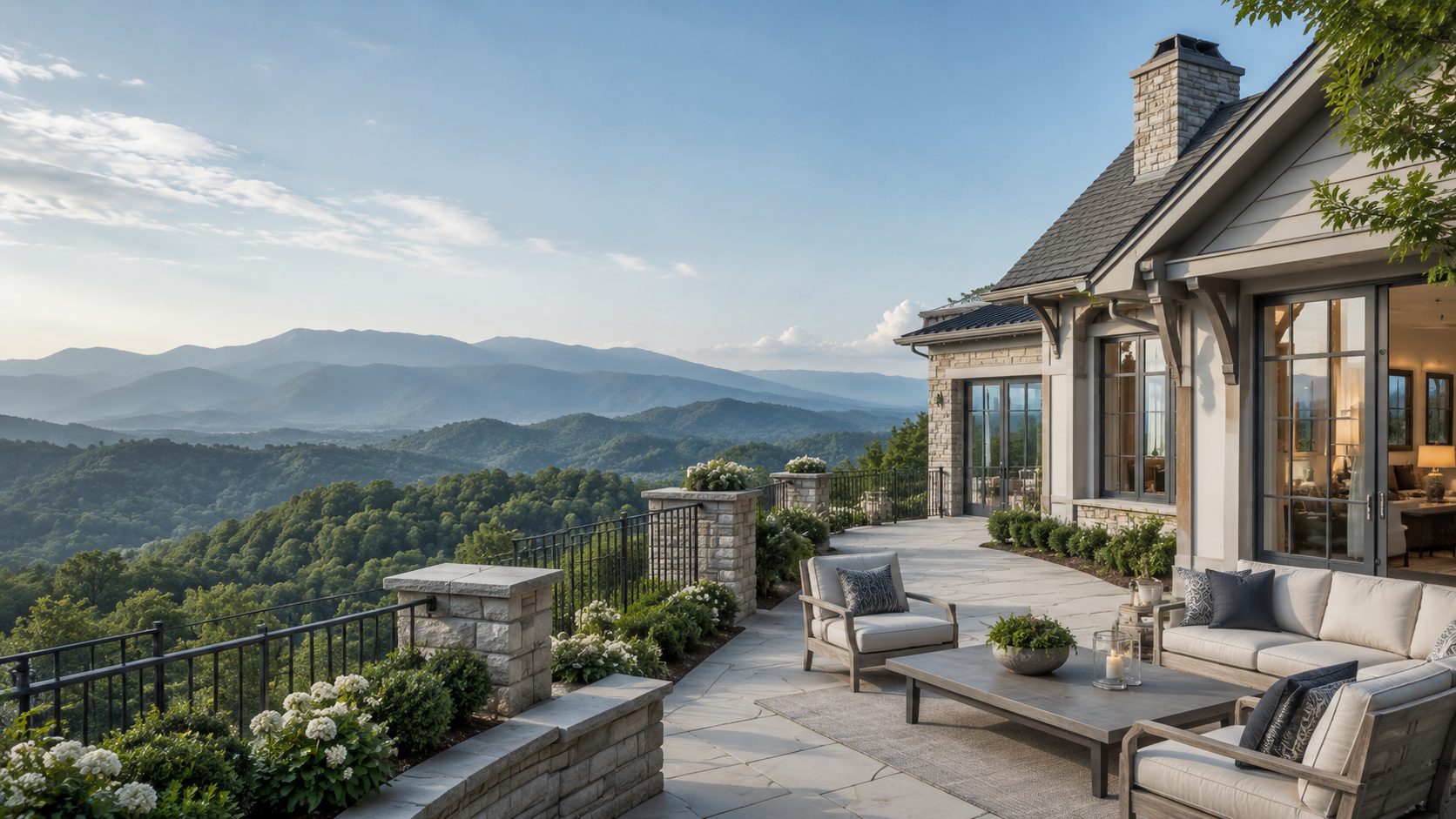 Luxury mountain-view terrace with blue-gray furnishings, light stone architecture, and panoramic East Tennessee scenery.